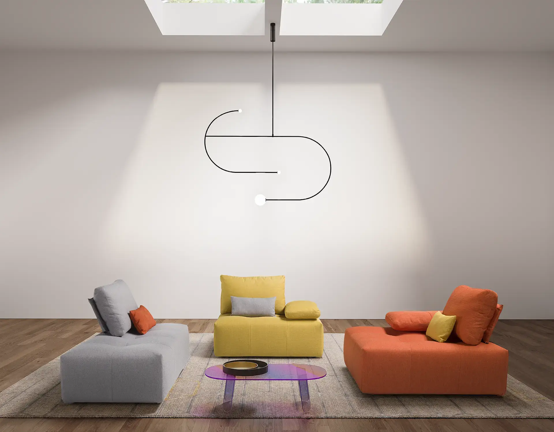 Tre moduli del divano Rubik separati, in grigio, giallo e arancio, sotto un lucernario